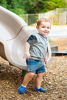 Young toddler boy child playing on slide