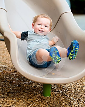 Young toddler boy child playing on slide