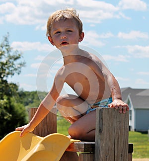 Young Toddler Boy Unsure of going down a swimming pool slide