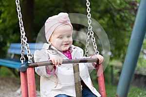 A Young Toddler Girl Swinging in a Park