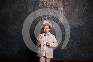 Young toothless boy posing against blue and gold wall. Copy space