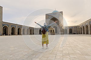 Young tourist with arms up inside the Kalyan Mosque, part of the Po-i-Kalyan complex in Bukhara, Uzbekistan photo