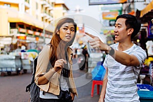 Young tourist asking for directions from local people