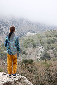 Young tourist boy looking to the ruins of ancient Pisidian city Termessos in Turkey