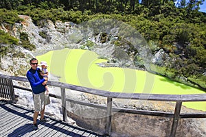 Young tourist with a child. Devil's Bath pool in Waiotapu Therma