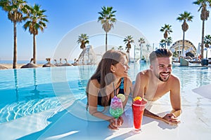 Young couple on infinity pool cocktails