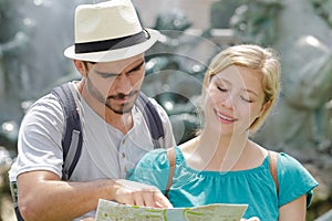 young tourist couple with map outdoors photo