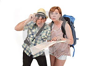 Young tourist couple reading city map looking lost and confused loosing orientation with girl carrying travel backpack