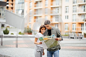 Young tourist couple traveling on holidays outdoors smiling happy. Caucasian family with city map in search of attractions