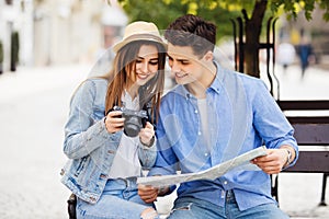 Young tourist couple traveling on holidays outdoors smiling happy. Caucasian family with city map in search of attractions. Travel