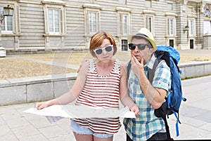 Young tourist couple visiting Europe reading city map looking lost and confused loosing orientation