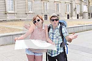 Young tourist couple visiting Madrid in Spain lost and confused loosing orientation
