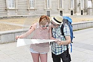 Young tourist couple visiting Madrid in Spain lost and confused loosing orientation