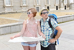 Young tourist couple visiting Madrid in Spain lost and confused loosing orientation