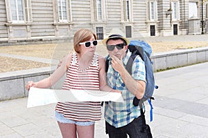 Young tourist couple visiting Madrid in Spain lost and confused loosing orientation