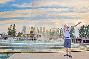 Young tourist on the fountain in National Park, Almaty