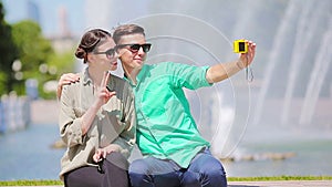 Young tourist friends traveling on holidays in Europe smiling happy. Caucasian couple with city map making selfie