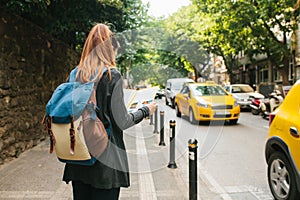 A young tourist girl with a backpack in a big city is watching a map. Journey. Sightseeing. Travel.