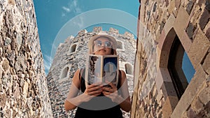 Young tourist girl looking at a brochure in Rabati Castle