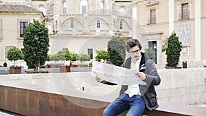 Young tourist is looking at a map in a street in Valencia, Spain, Europe