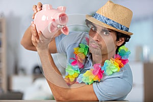 young tourist man with piggy bank
