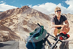 Young tourist man travel with bike in Himalaya montain photo