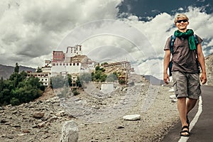 Young tourist man walks on road near Thiksey Monastery in India, Ladakh