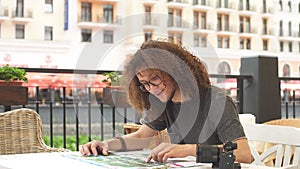 Young tourist with map sitting in cafe and think about travel