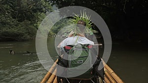 Young tourist is moving raft on river during summer day.