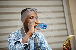 Young tourist photographer drinking mineral water