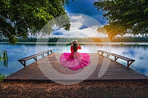 Young tourist sitting on Nong Han Pier. Near the lotus garden in Sakon Nakhon Province,Thailand