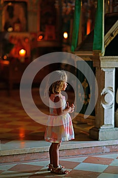 A young tourist in the small church of the monastery of the Virgin Mary in Paleokastritsa