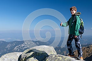 Young tourist standing on top of hill