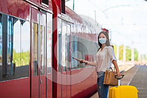 Young tourist woman with baggage on the platform waiting for train