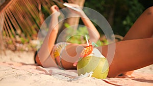 Young Tourist Woman in Bikini Lying Sunbathing on Tropical Paradise Sandy Beach and Using Mobile Tablet Gadget. 4K