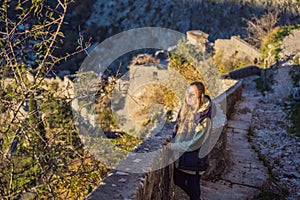 Young tourist woman enjoying a view of Kotor Bay, Montenegro. Kotor Old Town Ladder of Kotor Fortress Hiking Trail