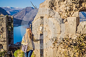 Young tourist woman enjoying a view of Kotor Bay, Montenegro. Kotor Old Town Ladder of Kotor Fortress Hiking Trail