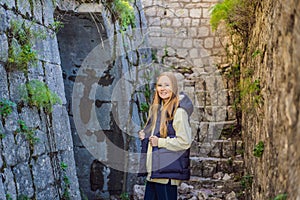 Young tourist woman enjoying a view of Kotor Bay, Montenegro. Kotor Old Town Ladder of Kotor Fortress Hiking Trail