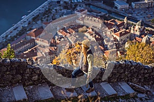 Young tourist woman enjoying a view of Kotor Bay, Montenegro. Kotor Old Town Ladder of Kotor Fortress Hiking Trail