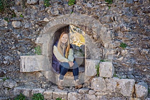 Young tourist woman enjoying a view of Kotor Bay, Montenegro. Kotor Old Town Ladder of Kotor Fortress Hiking Trail