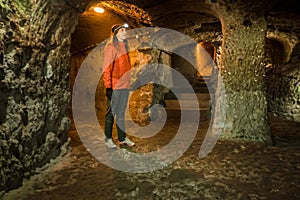 Young tourist woman explore ancient Derinkuyu underground cave city