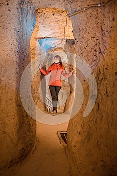 Young tourist woman explore ancient Derinkuyu underground cave city