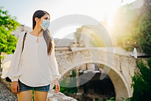 Young tourist woman with face mask travelling to European cities during coronavirus pandemic outbreak. Travel to Europe amid COVID