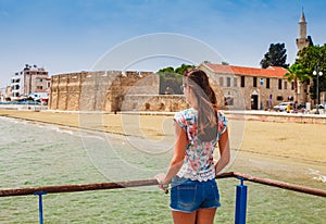 Young tourist woman looking at medieval castle in Larnaca, Cyprus