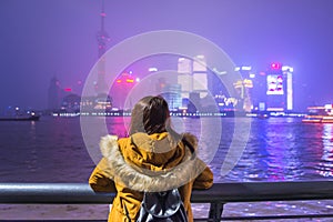 Young tourist woman looking at view of the bund in shanghai, china.