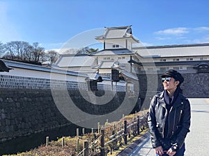 Young tourist woman smiling and enjoying beautiful view of Kanazawa Castle in Japan