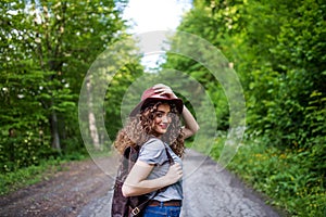 Young tourist woman traveller with backpack walking in nature.