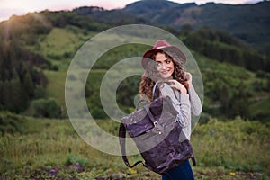 Young tourist woman traveller with backpack walking in nature.