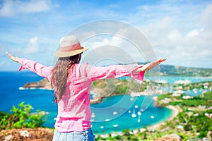 Young tourist woman with view of English Harbor from Shirley Heights, Antigua, paradise bay at tropical island in the