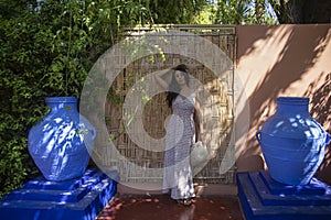 Young tourist on a wooden wall and a blue environment of the Majorelle garden in Marrakech (Morocco).